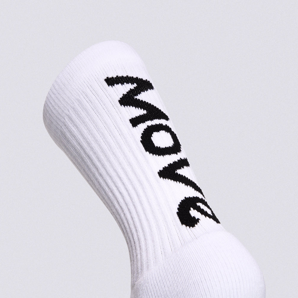 A close-up of a white ribbed crew sock with the word 'MOVE' knitted in black across the side, shown against a light gray background.