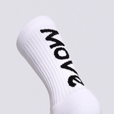 A close-up of a white ribbed crew sock with the word 'MOVE' knitted in black across the side, shown against a light gray background.